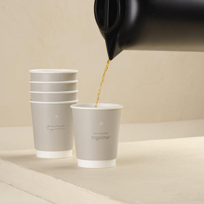 Pouring coffee from a black kettle or Borosilicate Vacuum Jug into a paper cup