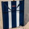 Navy and white striped folded beach mat on a sandy beach 