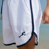 White shorts with a Albahar logo on a beach 