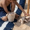 Child playing with sand toys on a beach mat