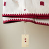 Baby blanket with geometric patterns with Qatar flag and a Sama tag on a beige background