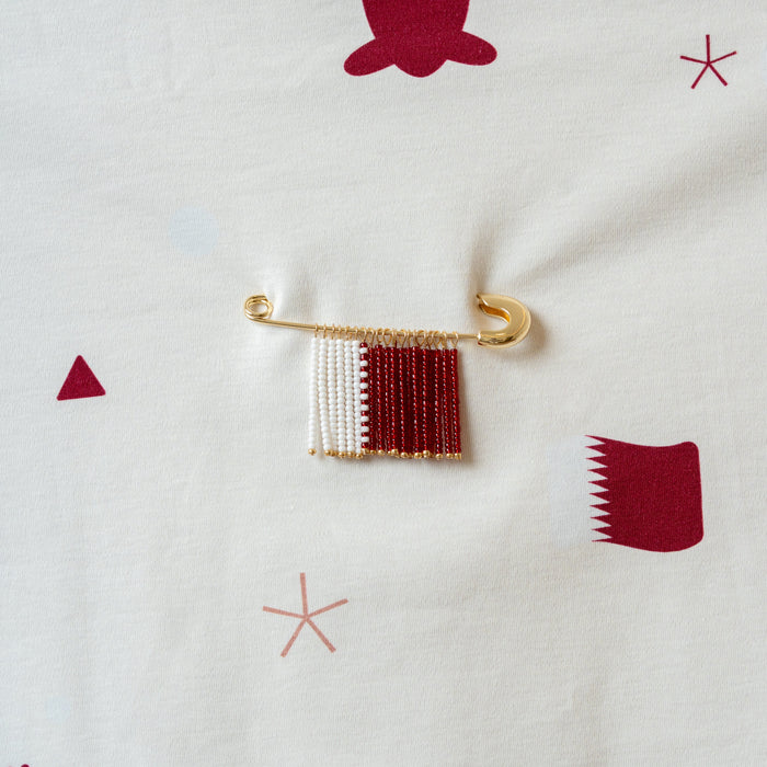 Decorative brooch or safety pins withQatar flag  pattern on a baby blanket