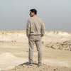 Person wearing Qatar Sweater Trouser Set - Sama Beige back standing in a desert landscape with a clear sky