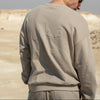 Person wearing a beige sweatshirt in a desert setting