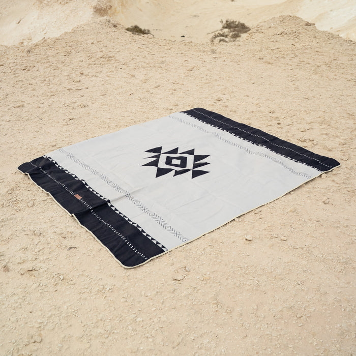 Sadu patterned rug on a sandy desert background