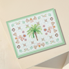 Multi functional serving board with a palm tree and floral patterns on a beige background
